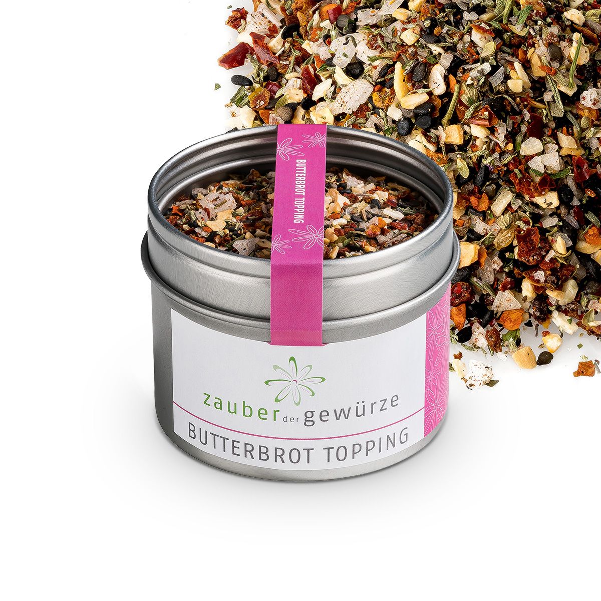Geöffnete Dose mit Butterbrot Topping. Rosa Band mit Schriftzug. Weißes Etikett mit Produktnamen und Logo. Streuung von Topping.