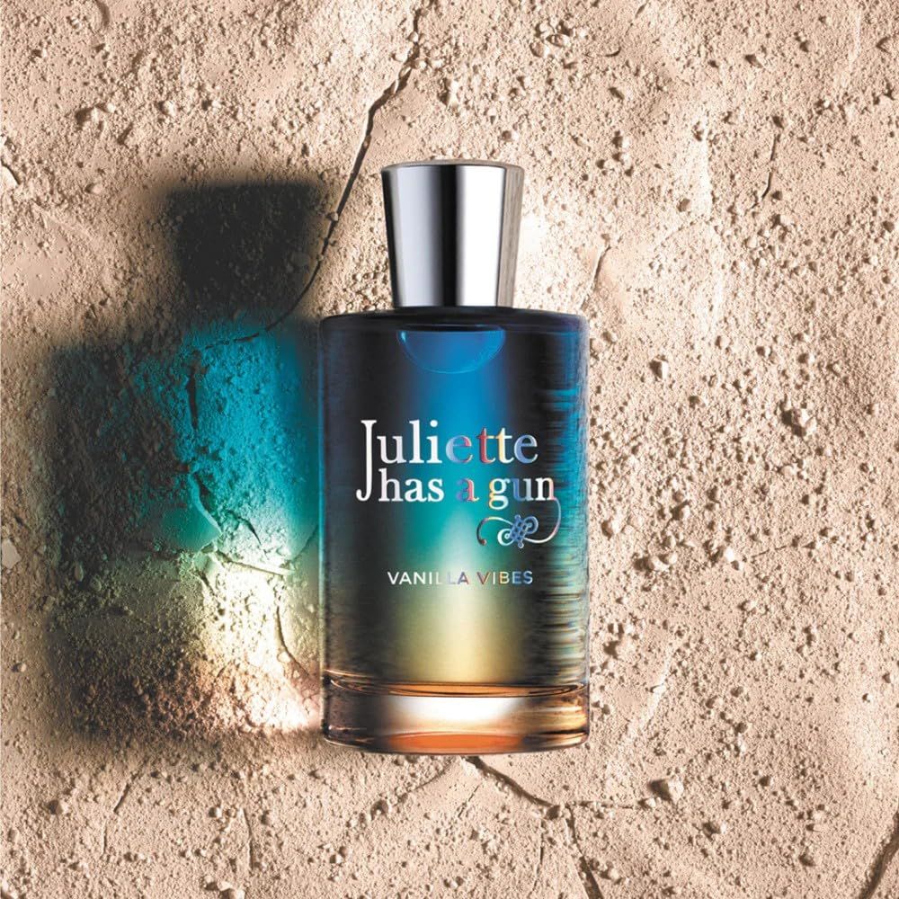 Juliette Has A Gun Vanilla Vibes Eau de Parfum Spray. Flakon auf sandigem Untergrund. Aufschrift: Vanilla Vibes.