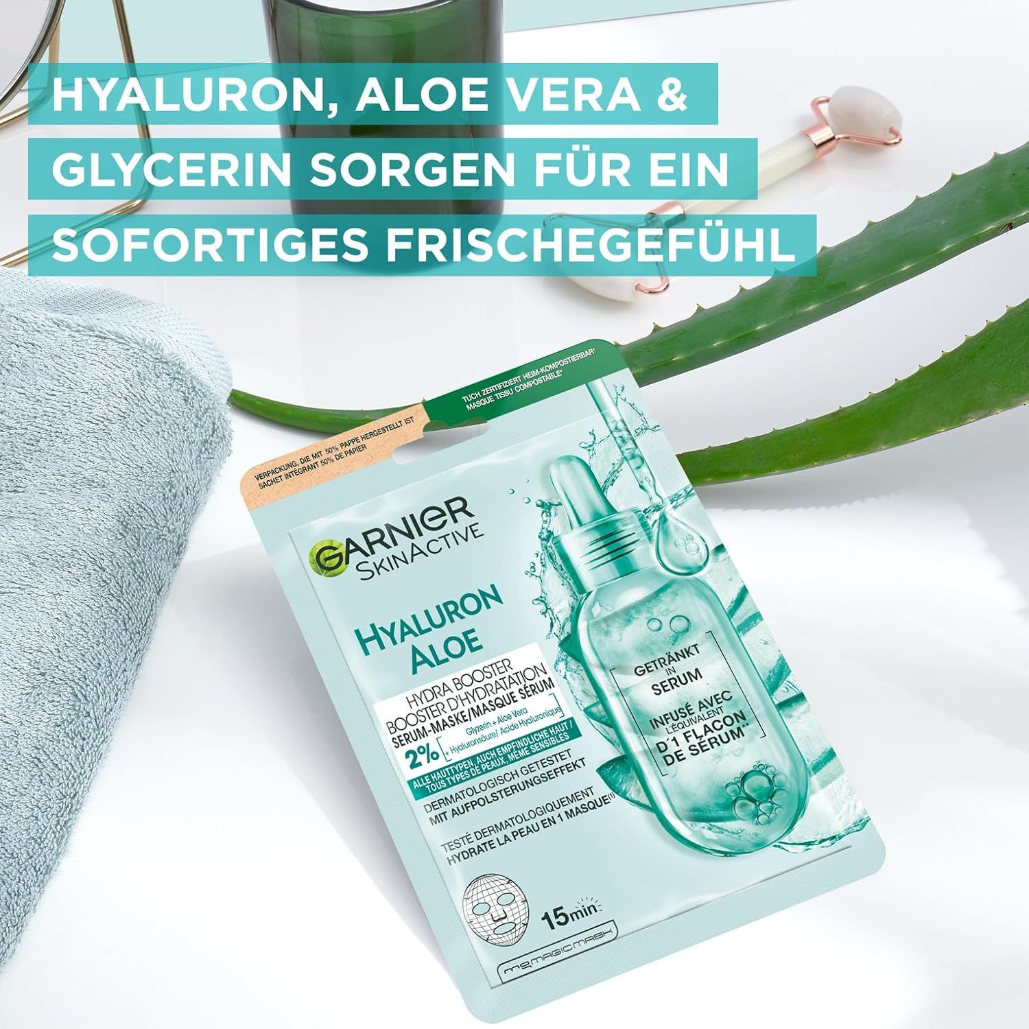 Garnier Tuchmaske Aloe Hydra Booster Serum. Produkt und Zubehör auf Handtuch. Logo und Produktinformationen.