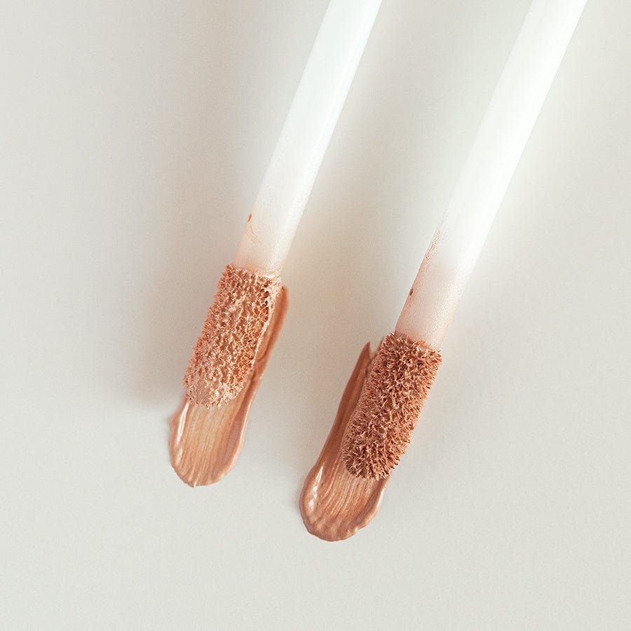 Zwei Applikatoren mit GRN Liquid Concealer beige oat. Schwammspitzen mit Produkt. Produktfarbe beige.