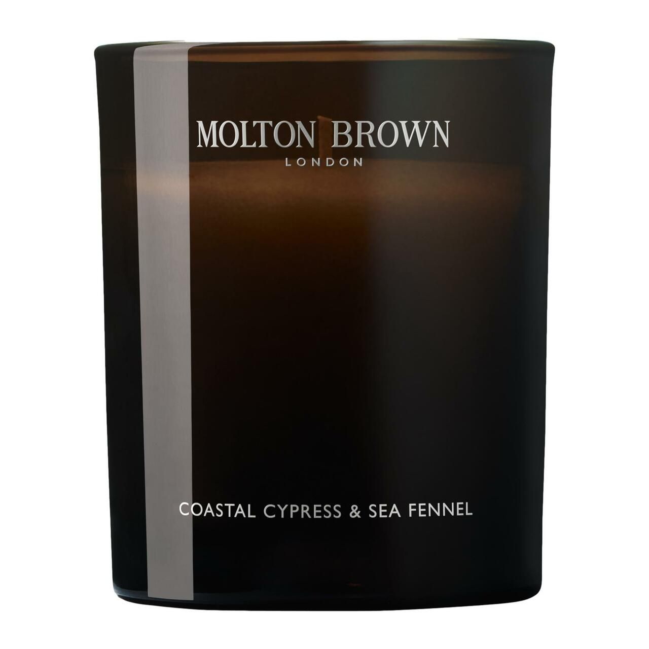 Dunkle Glas-Duftkerze mit weißem Streifen. Text: Molton Brown London, Coastal Cypress & Sea Fennel.