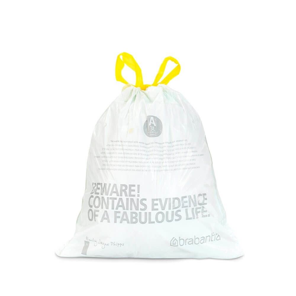 Weißer Müllbeutel mit gelben Schlaufen. Text: 'BEWARE! CONTAINS EVIDENCE OF A FABULOUS LIFE.' Marke Brabantia.