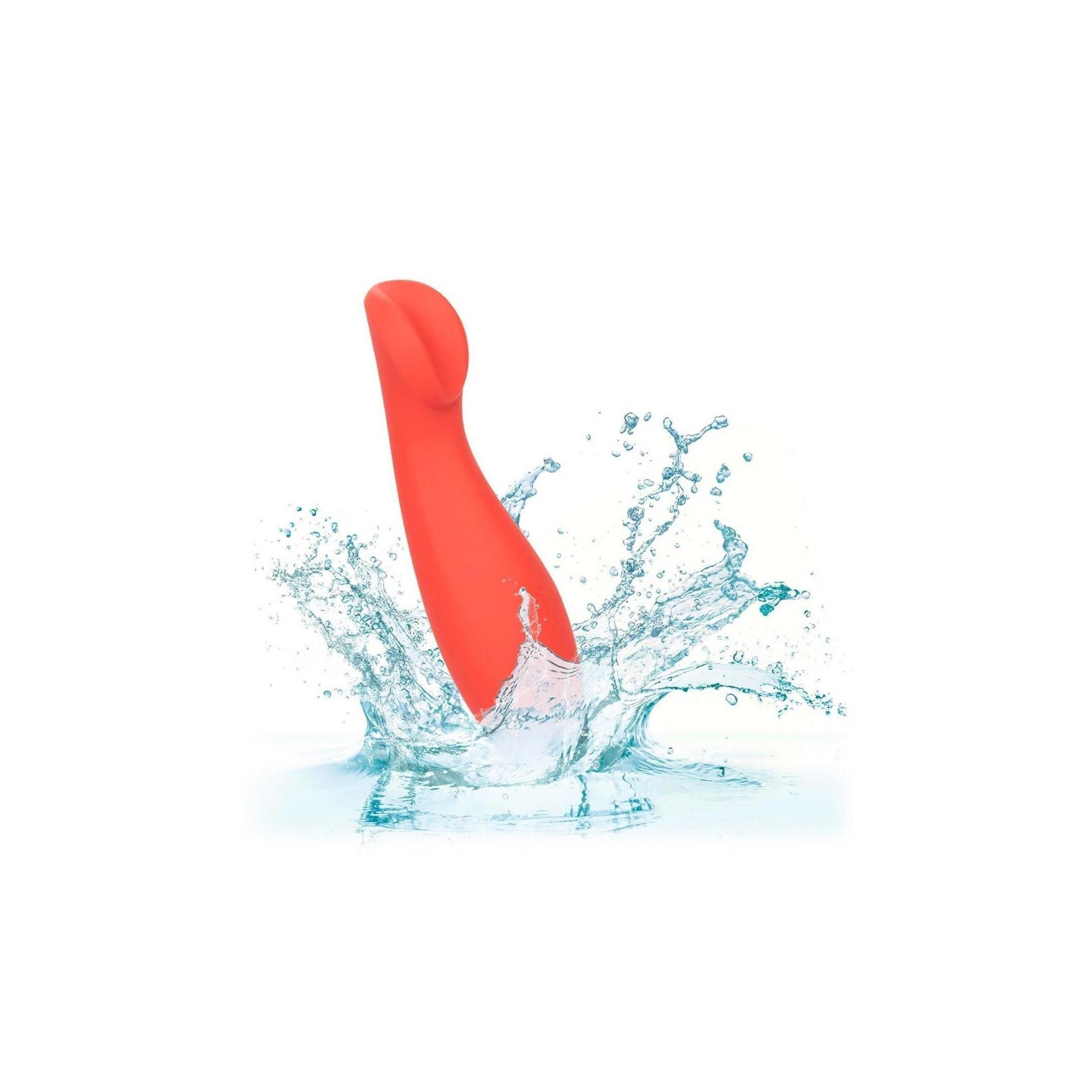 Roter Vibrator im Wasser. Wasserspritzer um das Produkt herum. Produkt im Gebrauch dargestellt.