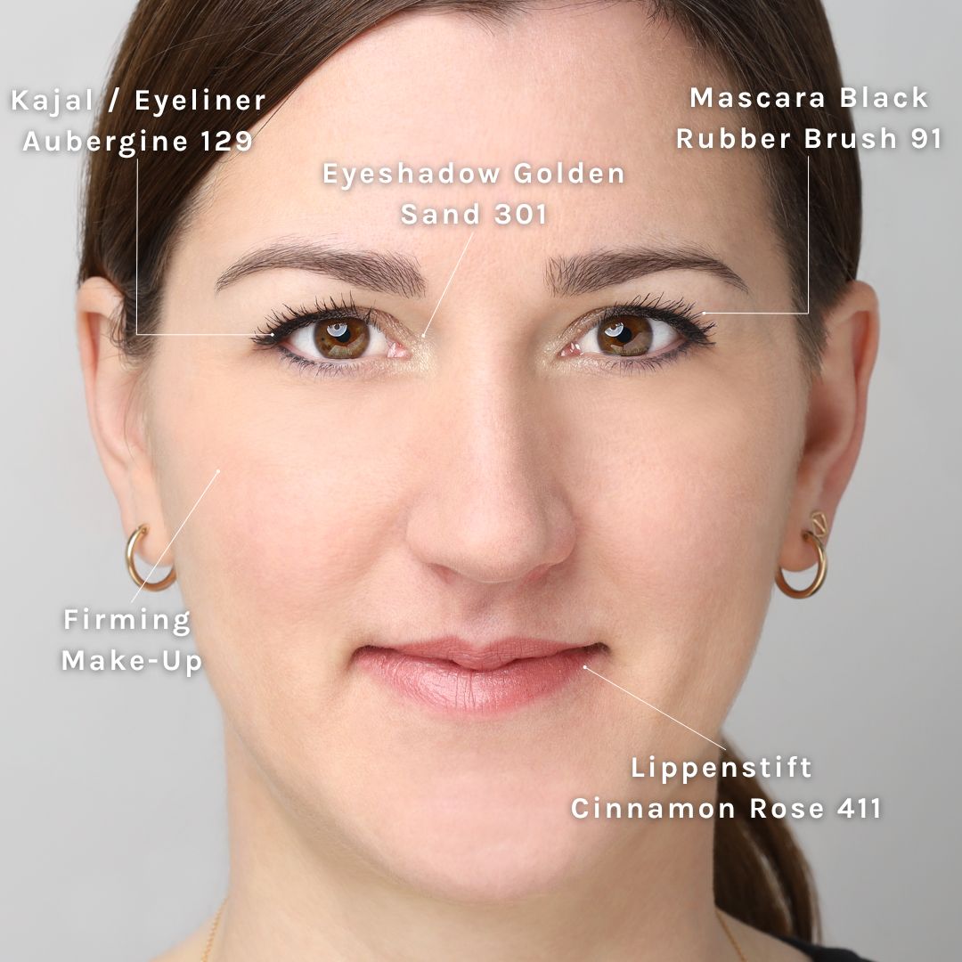 Nahaufnahme eines Gesichts mit Beschriftungen, die Kosmetikprodukte wie Kajal, Lidschatten, Lippenstift und Mascara hervorheben.