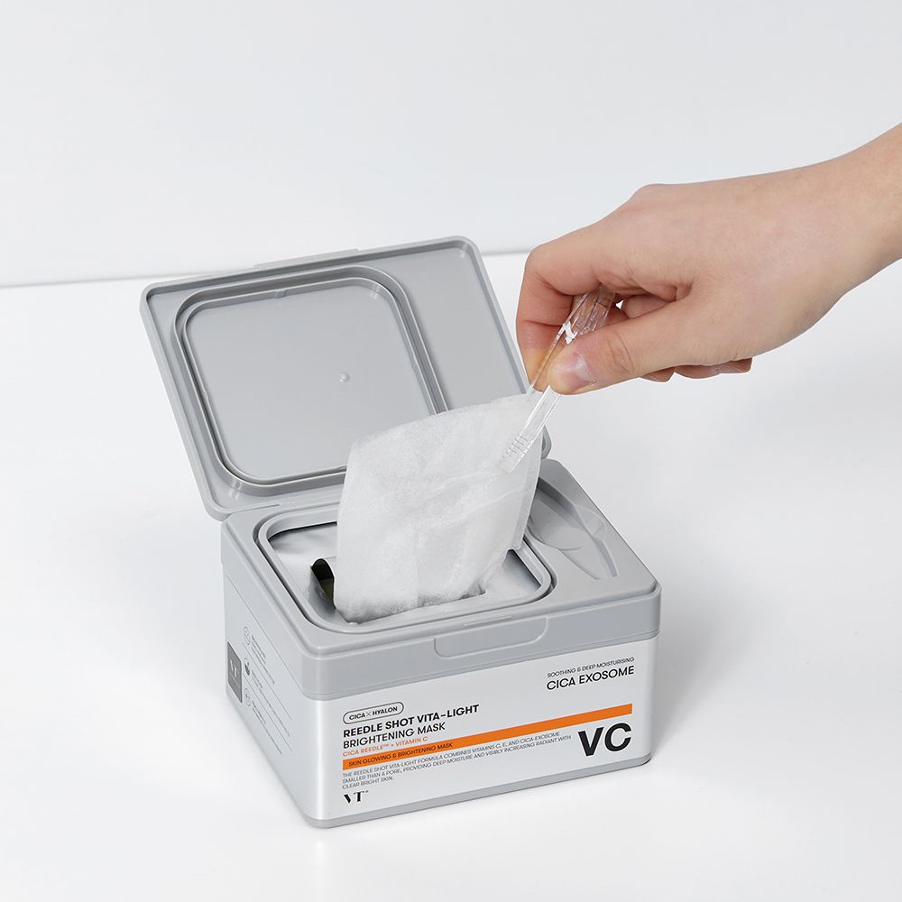 Hand entnimmt eine einzelne Gesichtsmaske aus einer geöffneten Box.