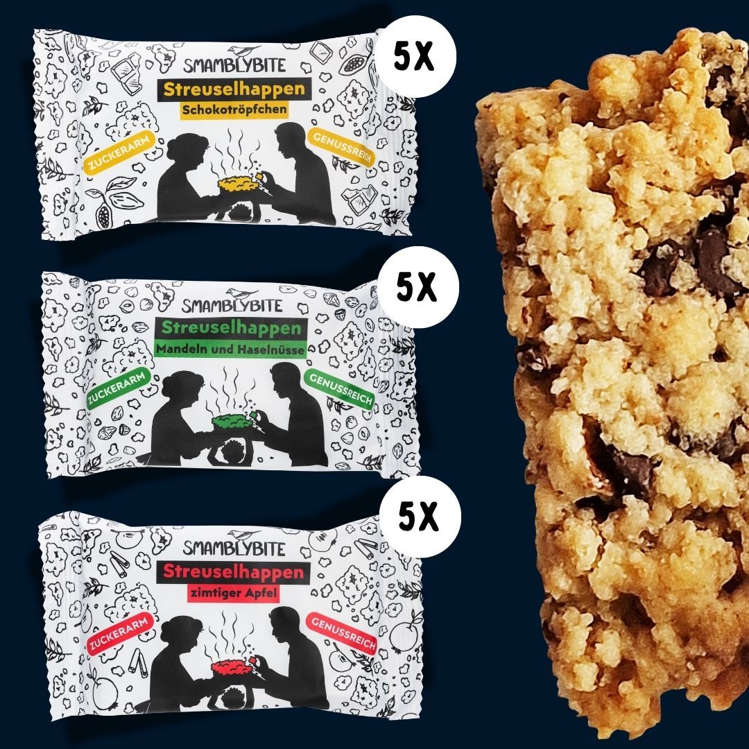 Drei Packungen Streuselhappen mit je 5 Stück. Aufschrift: SMAMBLYBITE, Streuselhappen, Schokotröpfchen, Zimtiger Apfel, Mandeln und Haselnüsse. Daneben ein Riegel.