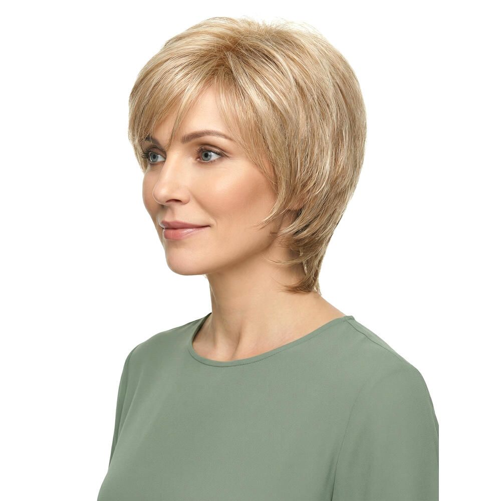Kurzhaarperücke, blond-braun meliert, mit Pony. Frau trägt ein grünes Oberteil. Seitenansicht.