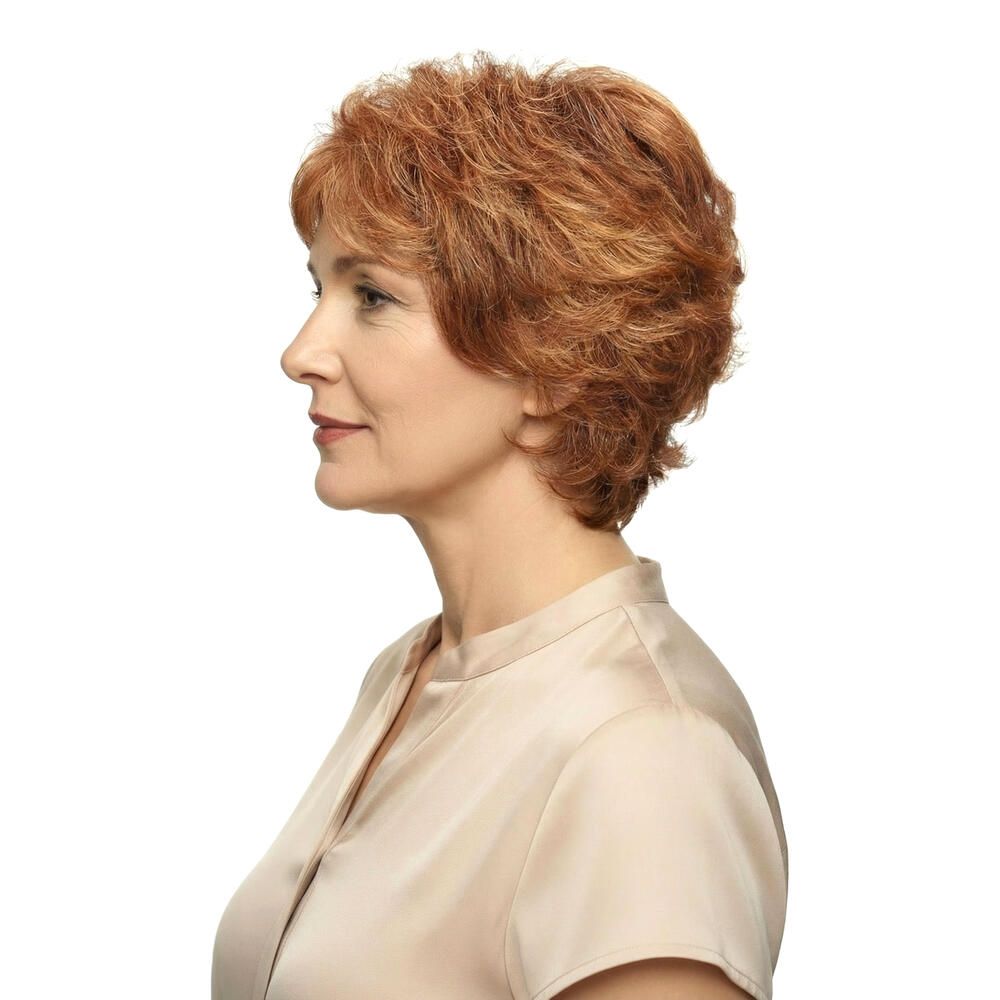 Profil einer Frau mit rotbrauner Perücke. Kurzer, gewellter Schnitt. Trägt ein beiges Oberteil.