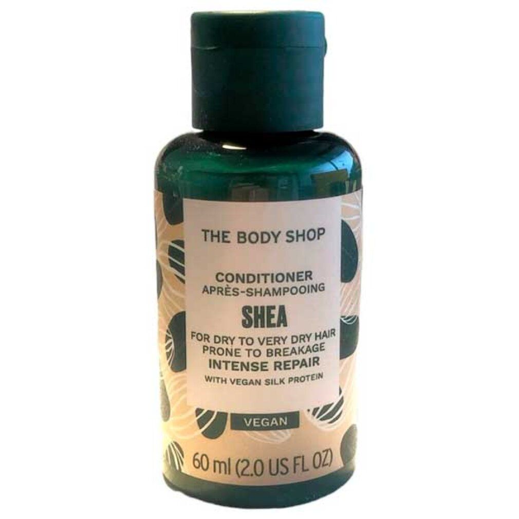 Konditionierer-Flasche. Grün, mit Aufschrift 'The Body Shop'. Enthält 'Shea' für trockenes Haar. Vegan.