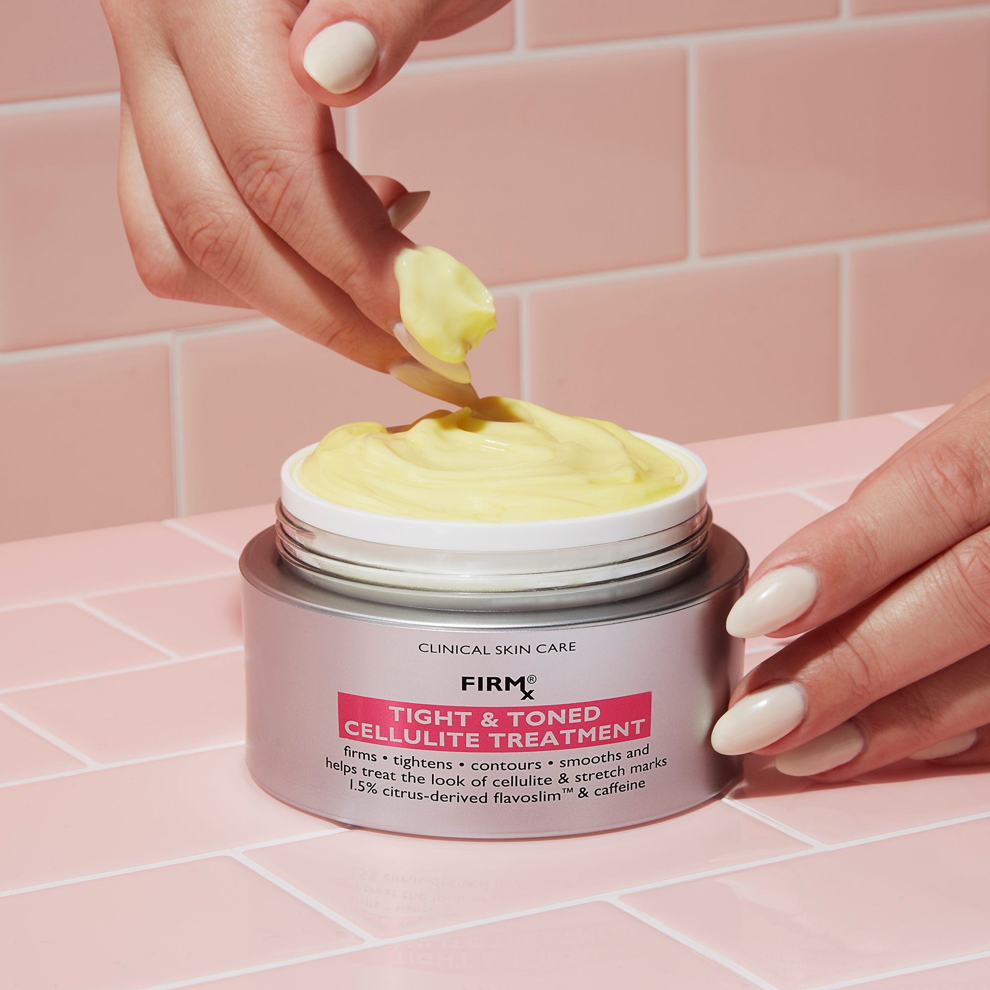 Hände entnehmen Creme aus Dose. Aufschrift: PETER THOMAS ROTH, FIRM X TIGHT & TONED CELLULITE TREATMENT. Gelbe Creme sichtbar.