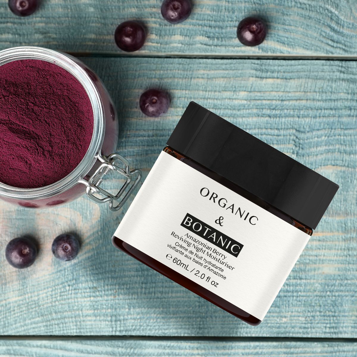 Creme-Tiegel mit schwarzem Deckel. Aufschrift: Organic & Botanic, Amazonian Berry Reviving Night Moisturiser. Daneben Beeren und ein Glas mit Pulver.