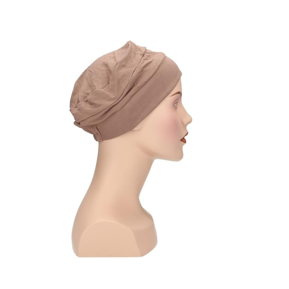 Beigefarbener Turban auf einer Schaufensterpuppe. Seitenansicht. Stoff mit Falten. Elastischer Saum.