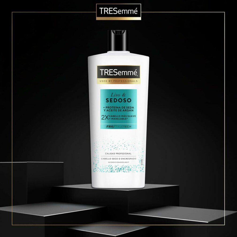 Weiße TRESemmé Shampoo-Flasche auf Podest. Aufschrift: Liso & Sedoso, Protein de Seda y Aceite de Argán. Für trockenes oder krauses Haar.