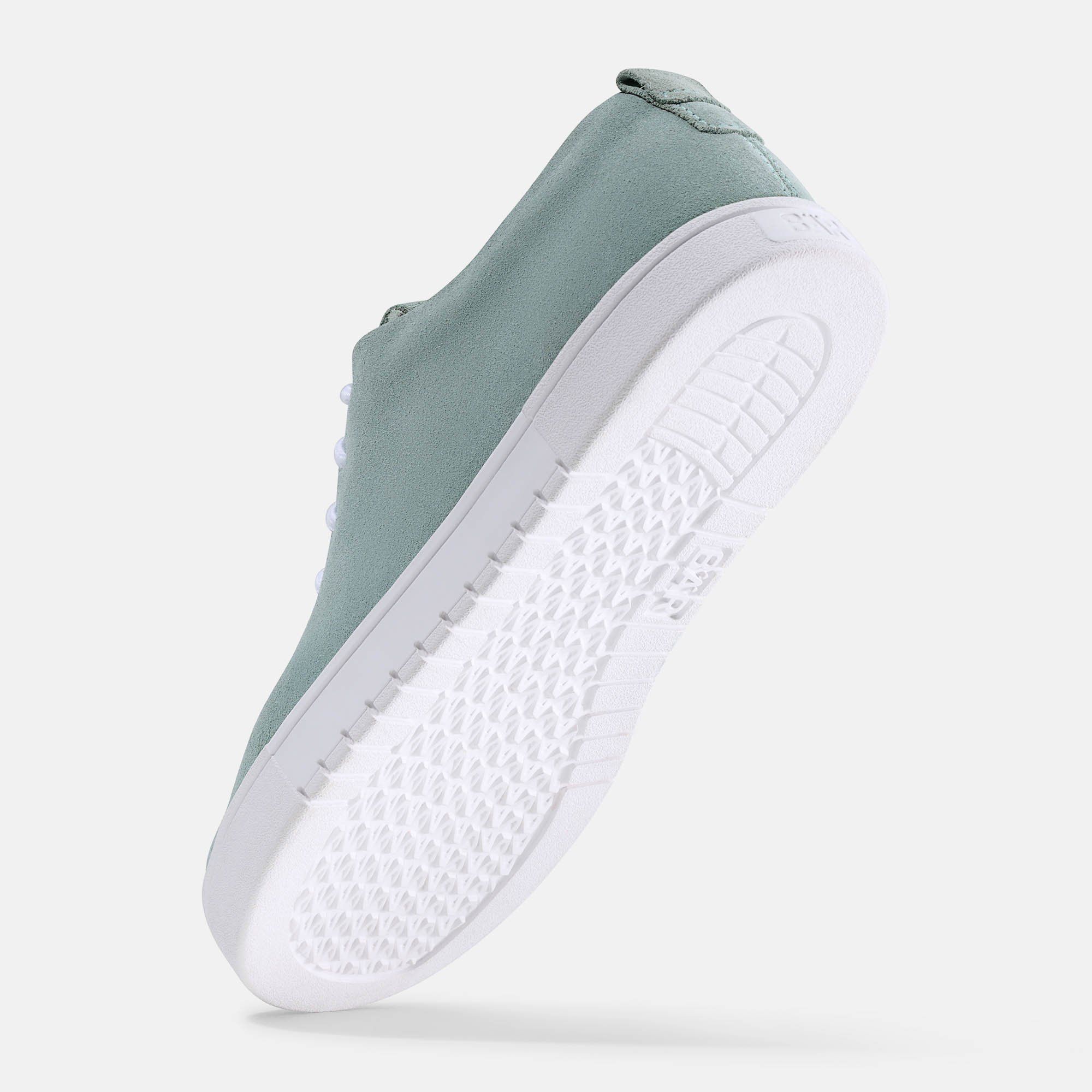 Unteransicht eines hellgrünen Sneakers mit weißer Sohle. Das Sohlenprofil ist sichtbar.