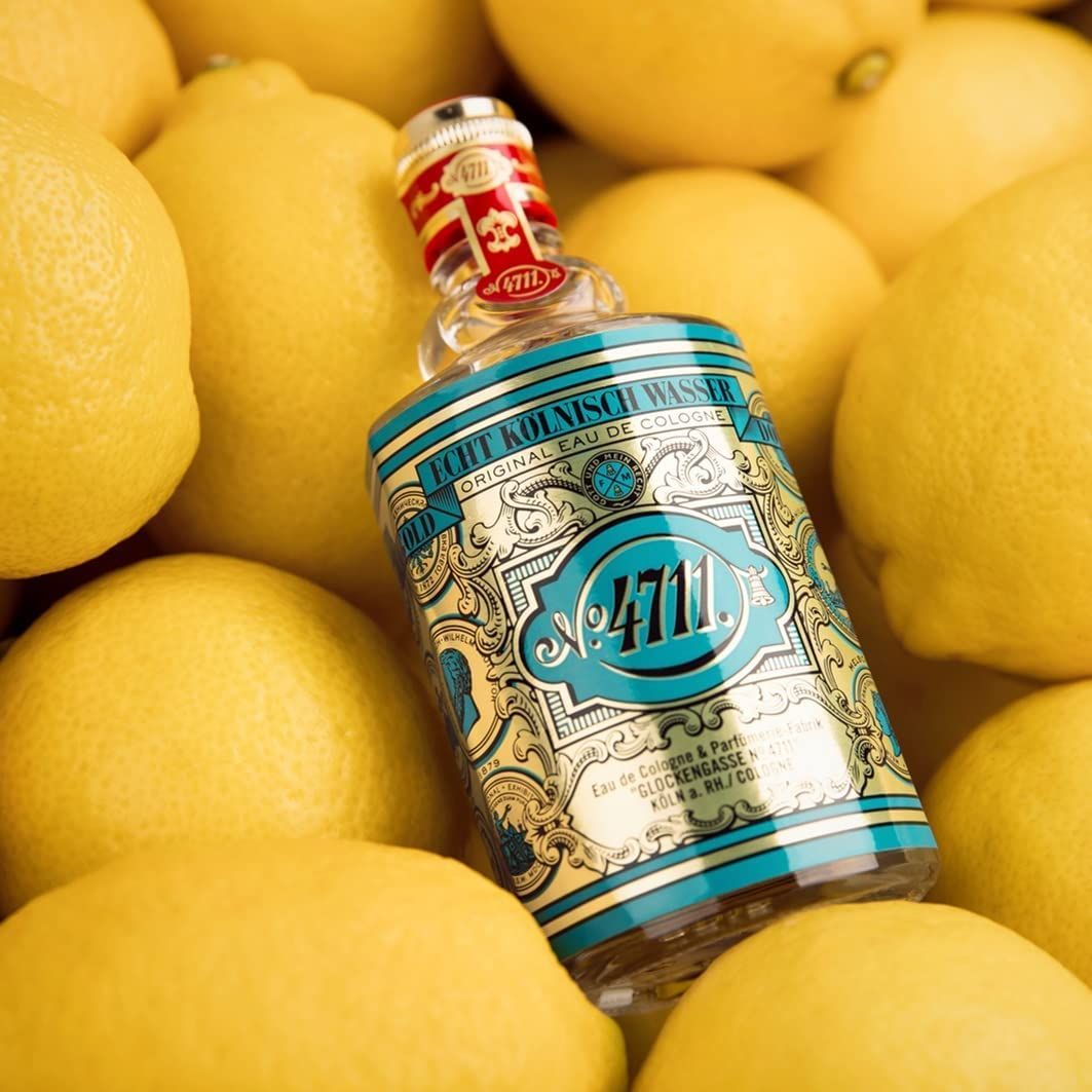 Eau de Cologne-Flakon auf Zitronen. Türkis-goldfarbenes Etikett mit Schriftzug und Logo.