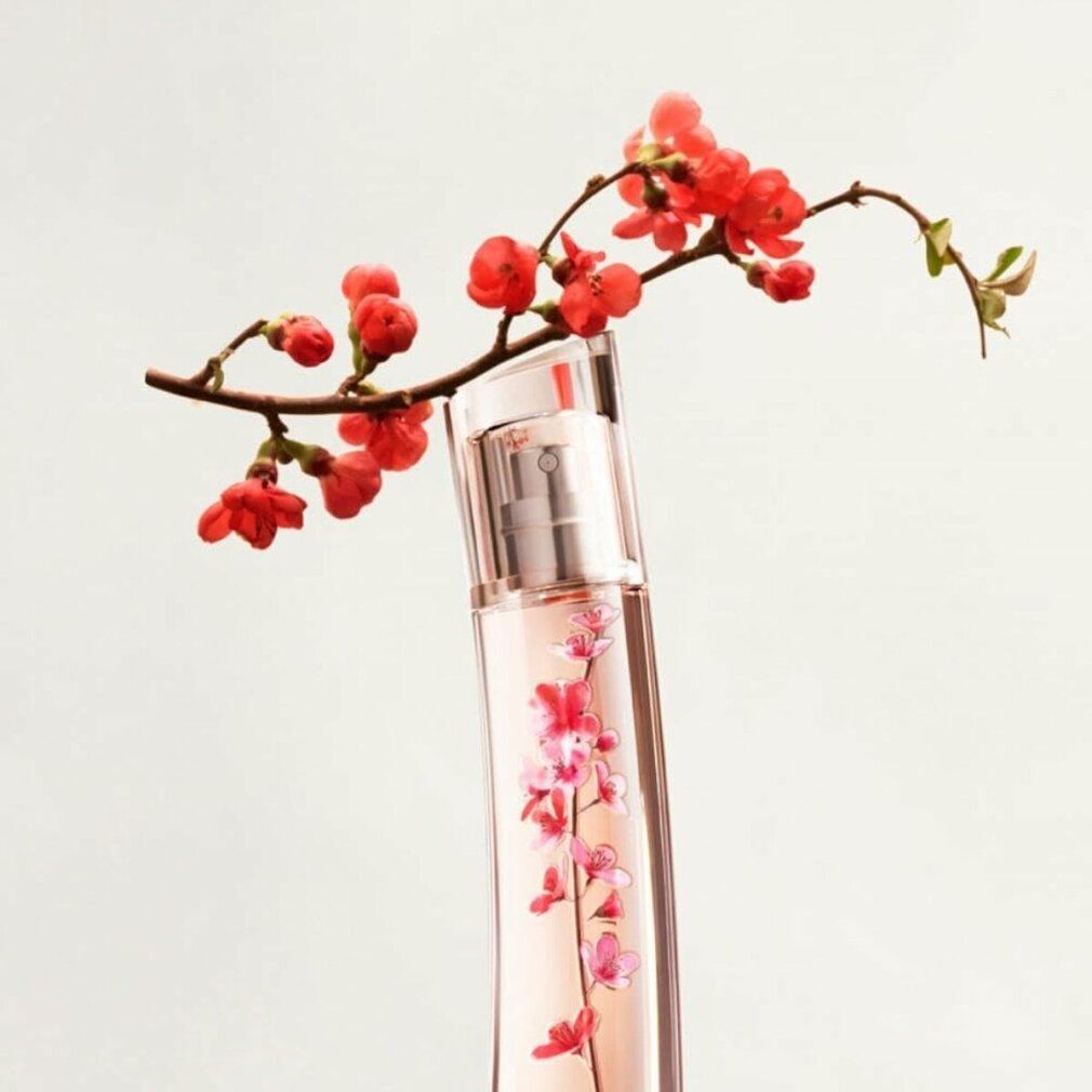 Parfümflakon mit floralem Design, mit Blütenzweig. Flakon mit pinkfarbenem Inhalt und floralem Muster. Schräge Form.