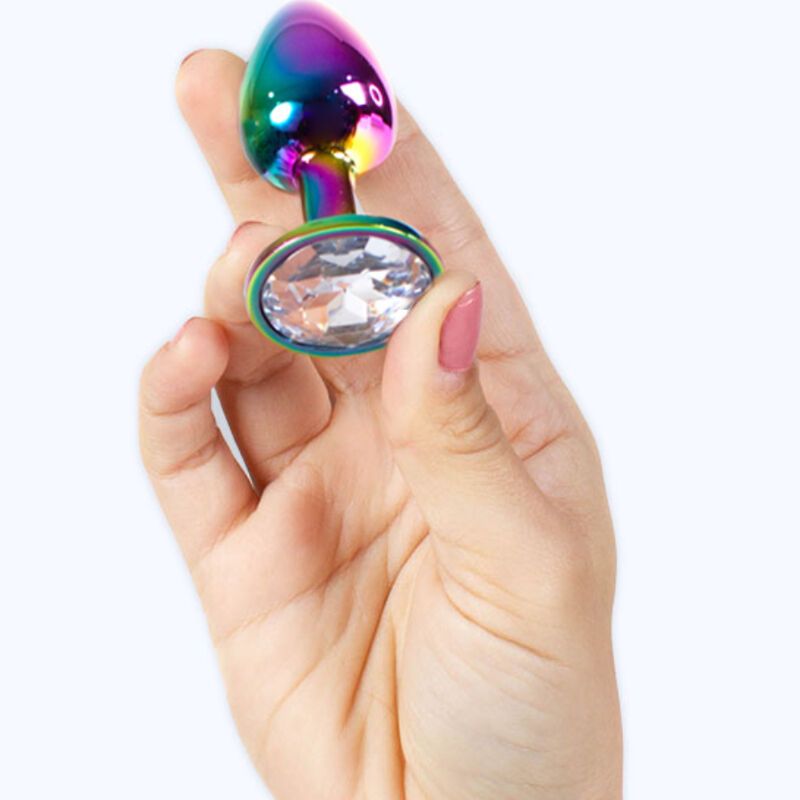 Regenbogenfarbener Metall-Butt Plug mit Kristall-Basis, gehalten in einer Hand mit rosafarbenen Fingernägeln.