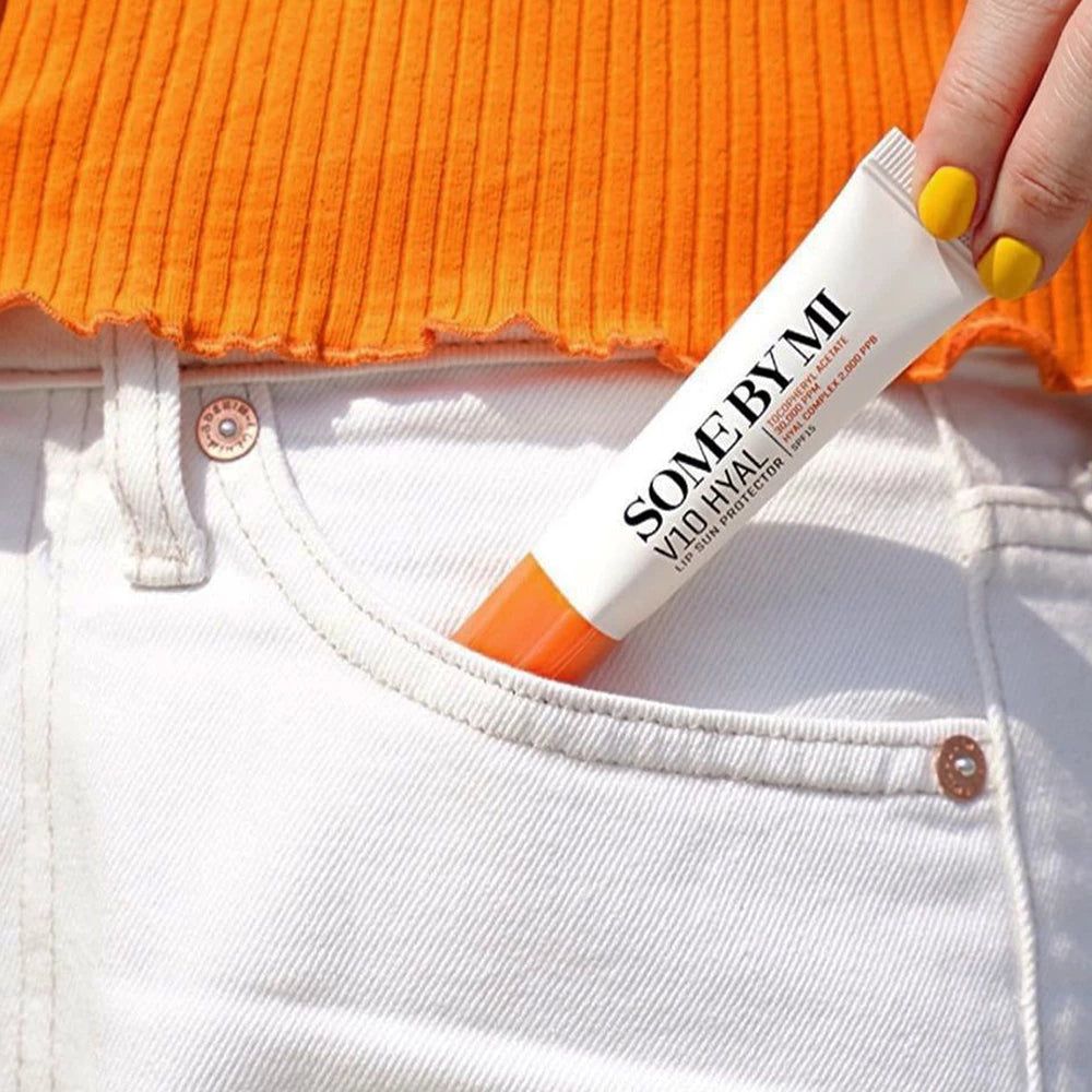 Weißes Tube-Lippenprodukt mit orangefarbenem Ende in einer Hosentasche. Aufschrift: SOME BY MI V10 HYAL.