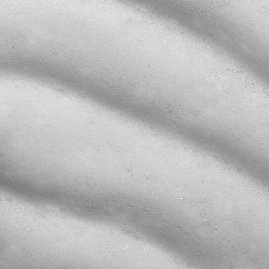 Nahaufnahme von weißem Schaum mit wellenförmiger Textur. Die Oberfläche ist leicht strukturiert.