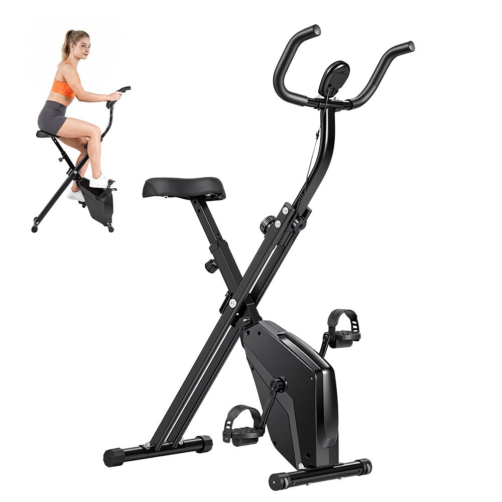 Schwarzes, klappbares Heimtrainer-Fahrrad. Frau darauf. Sattel, Lenker, Pedale und Display. Metallrahmen.