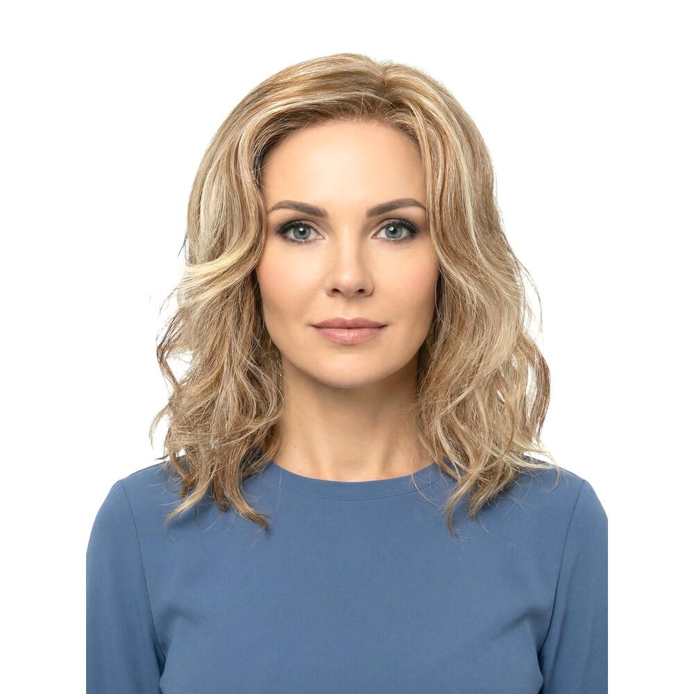 Frau mit blond gewellter Perücke. Frontale Ansicht. Die Perücke hat blonde und hellbraune Strähnen.