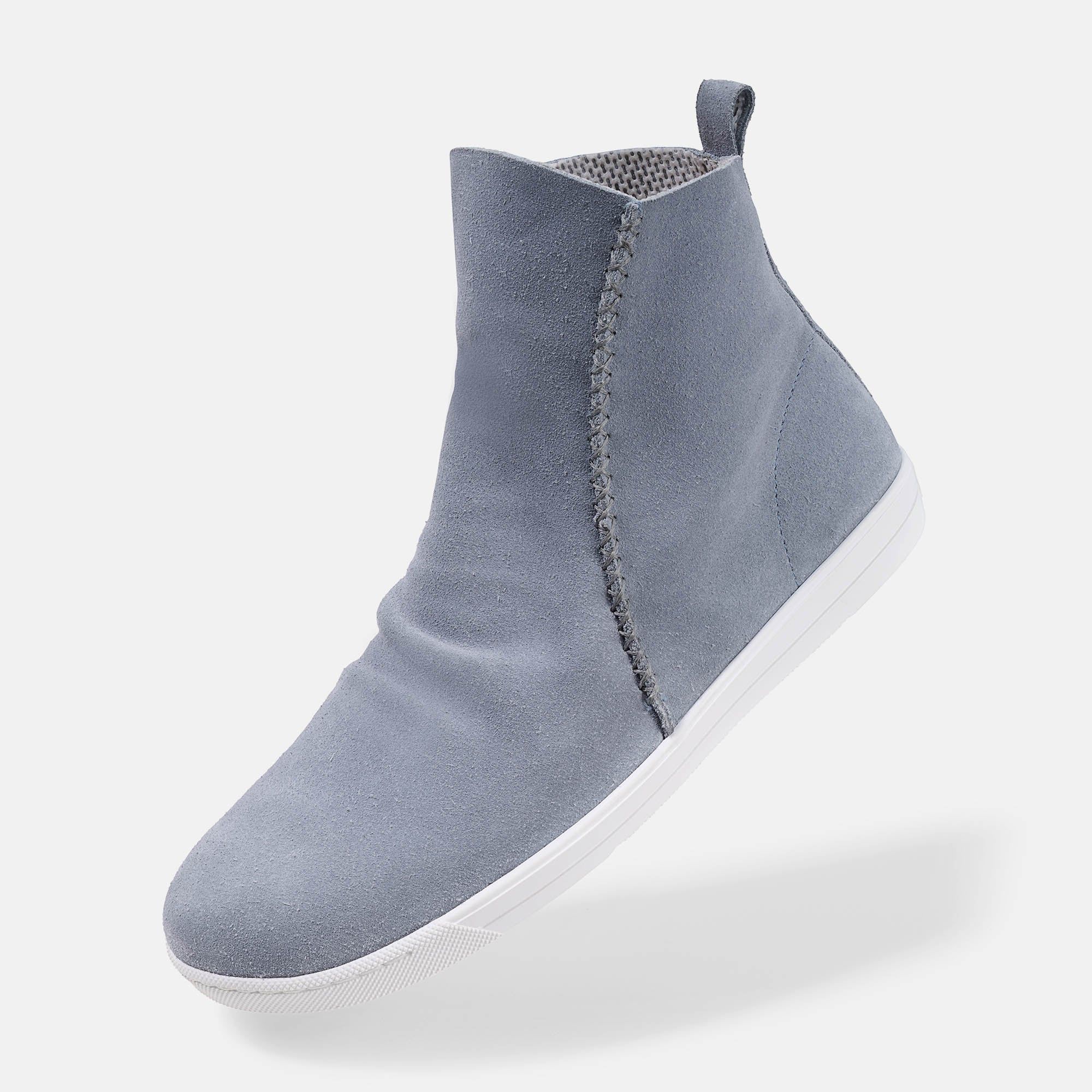 Hellblaue Stiefelette mit weißer Sohle. Reißverschluss an der Seite. Obermaterial aus Wildleder. Breite Passform.