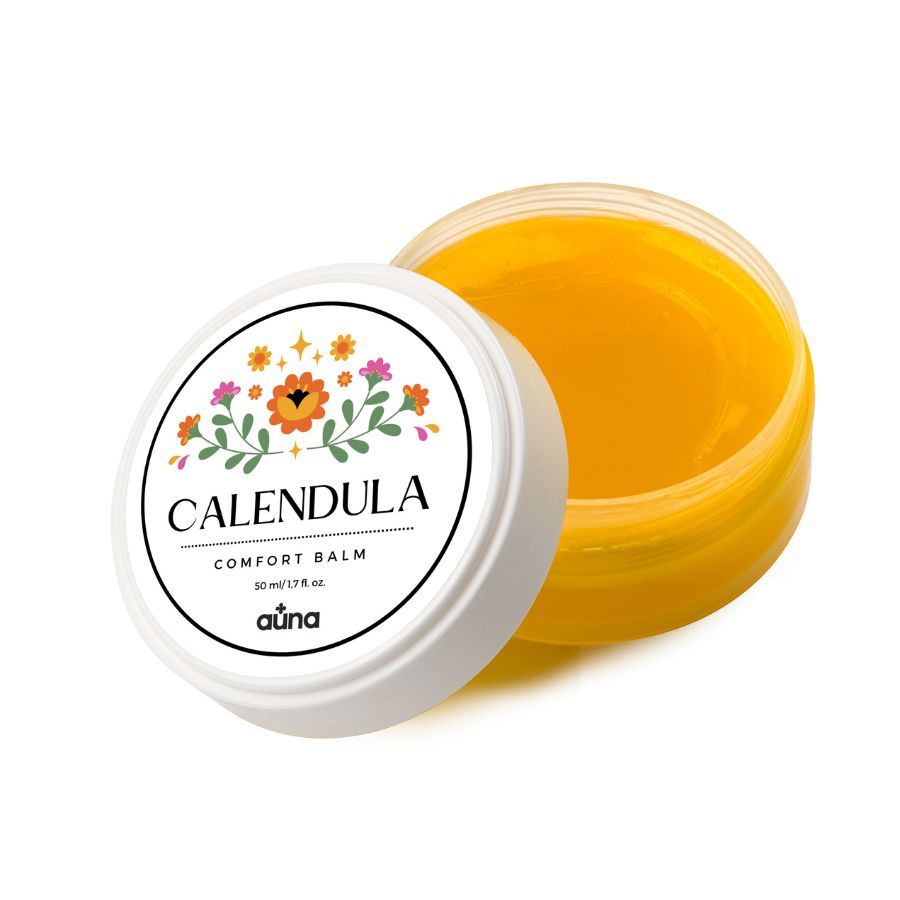 Geöffnete Dose mit Deckel. Aufschrift: CALENDULA COMFORT BALM. Blumenmuster. Marke: auna. Gelber Balsam sichtbar.