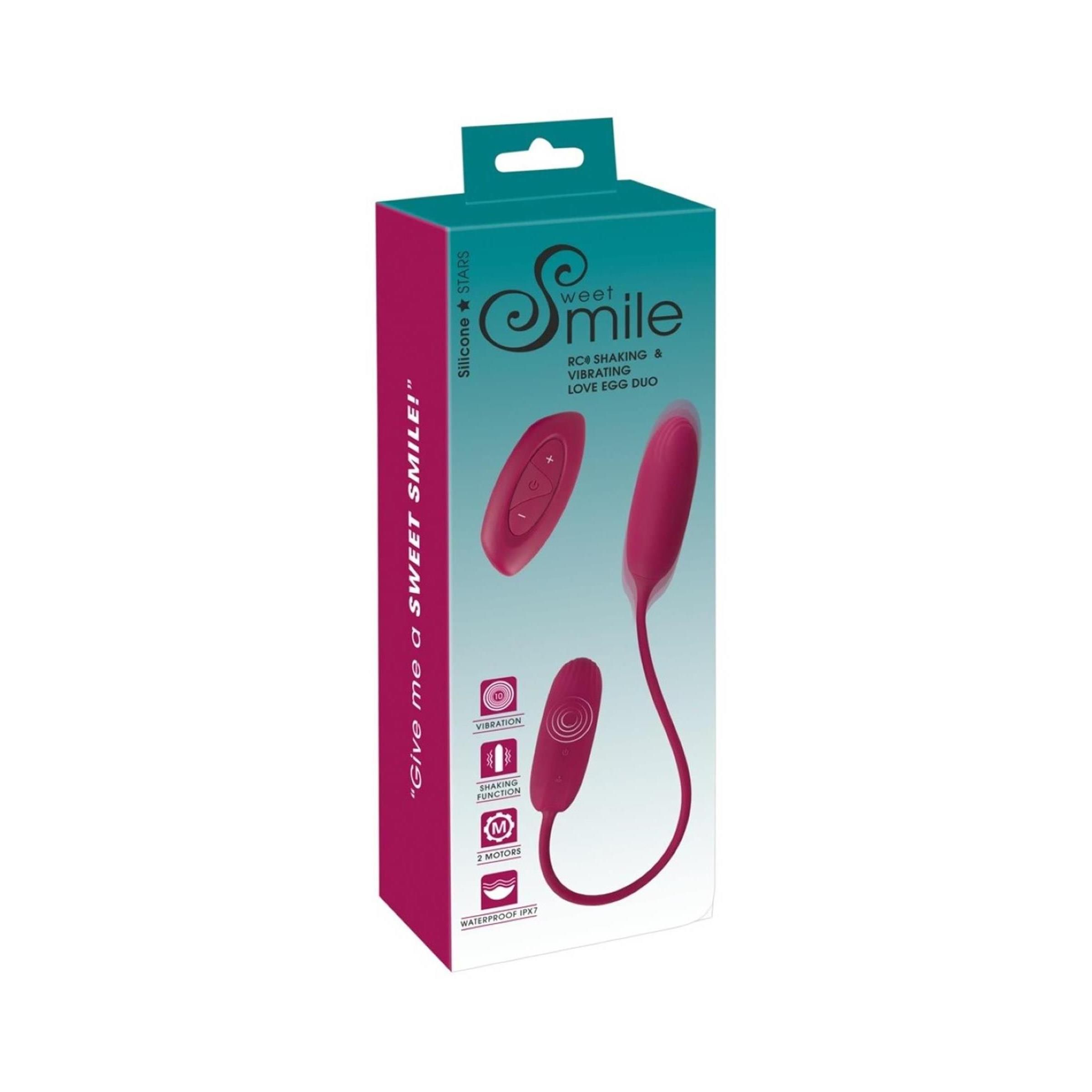 Verpackung mit Produktabbildung. Aufschrift: Sweet Smile. Enthält ein RC Shaking & Vibrating Love Egg Duo. Farbe: Pink.