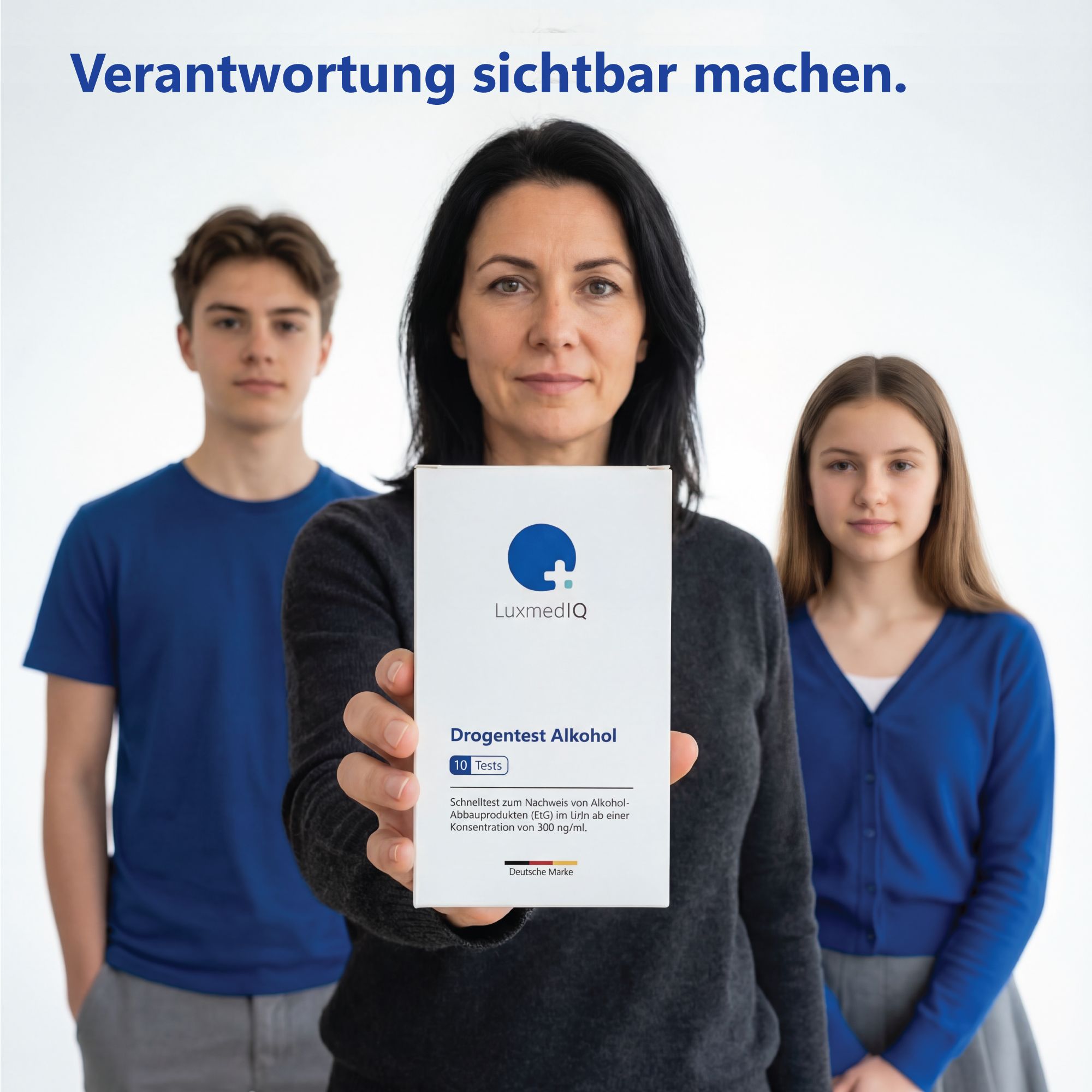 Frau hält Produktbox. Logo und Produktname sichtbar. Zwei Personen im Hintergrund. Hintergrund: weiß.