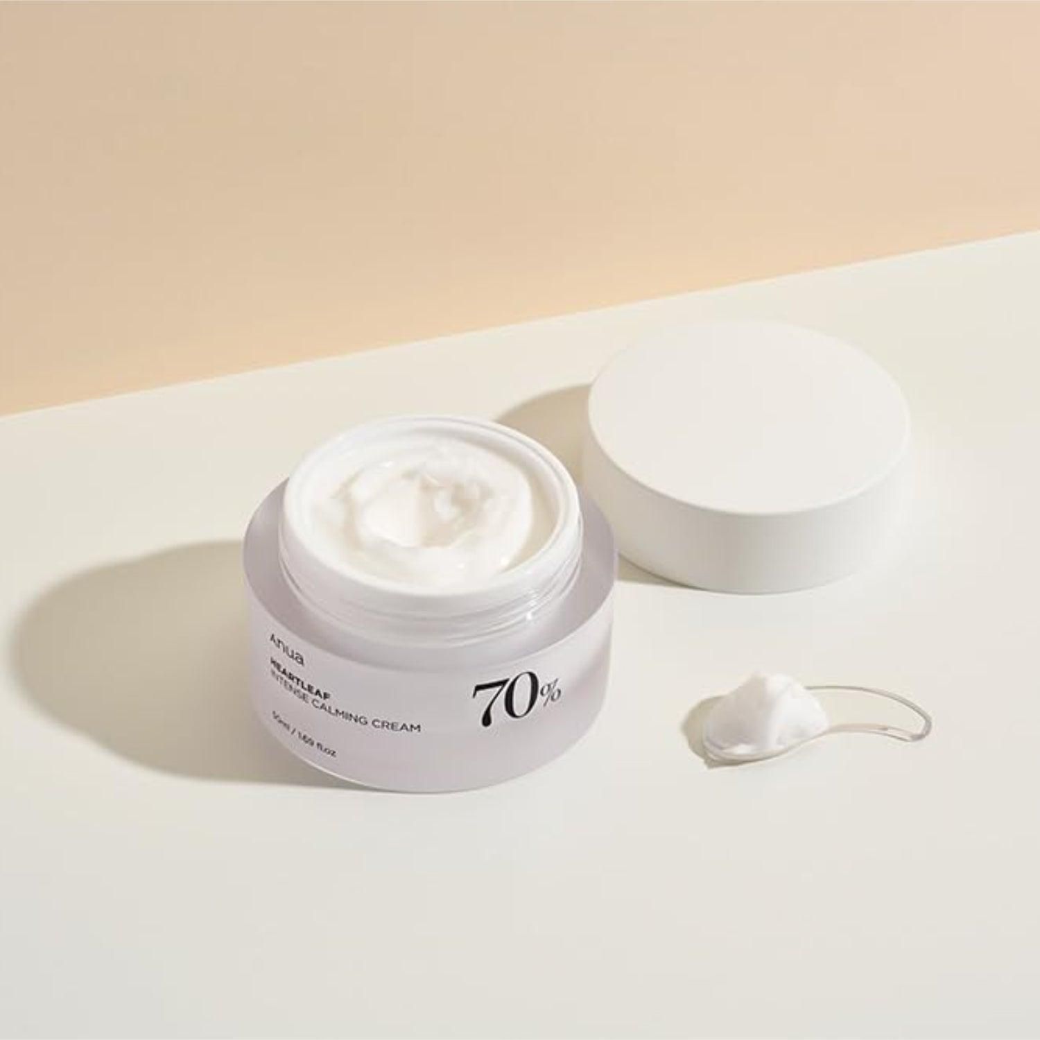 Creme in einem transparenten Tiegel mit Deckel. Ein Spatel und ein Klecks Creme daneben. Aufschrift: 70%.
