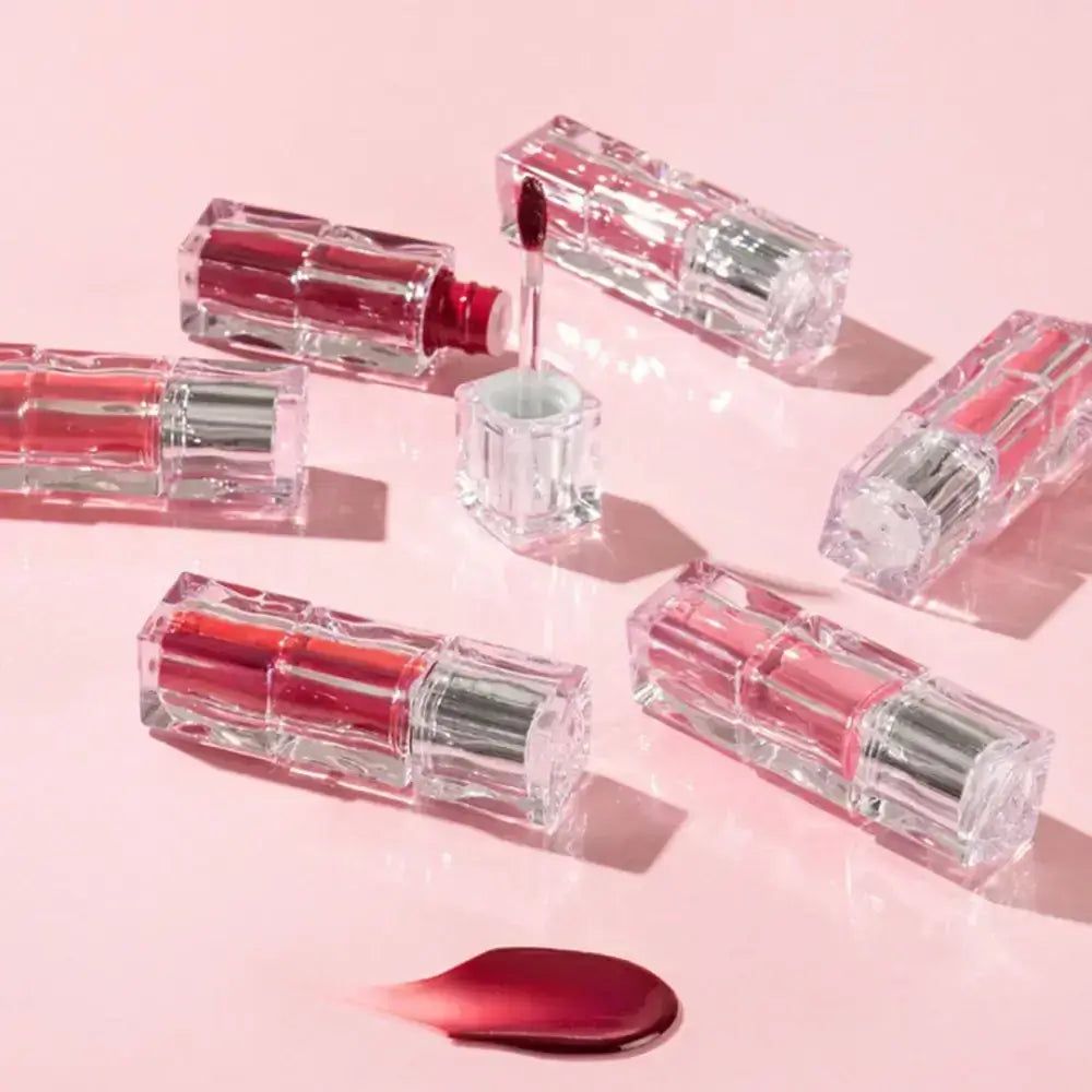 Nahaufnahme von TIRTIR Waterism Glow Tint Applikatoren in einer runden Glaslinse, umgeben von Fläschchen.