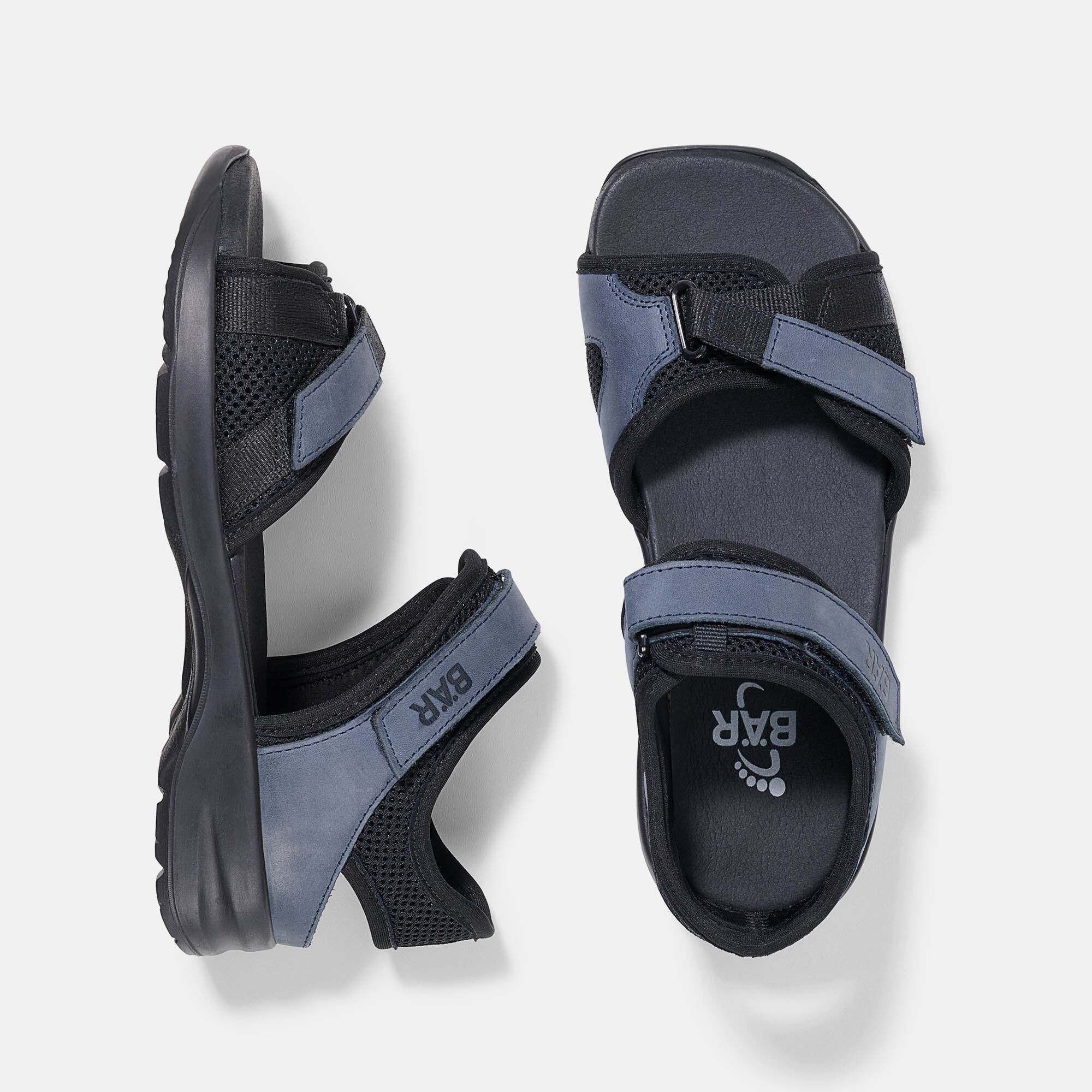 Oberansicht von schwarzen Sandalen mit blauen Riemen und Klettverschluss. Innensohle mit Logo.