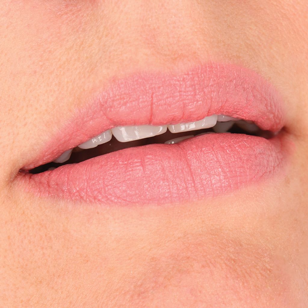 Nahaufnahme von Lippen, die mit rosafarbenem Lippenstift geschminkt sind. Deutliche Lippenkontur.