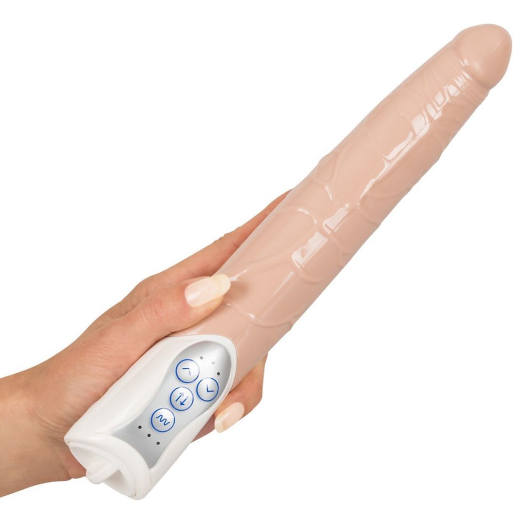 Beigefarbener Vibrator in einer Hand gehalten. Weißes Bedienfeld mit Knöpfen. Geformte Oberfläche.