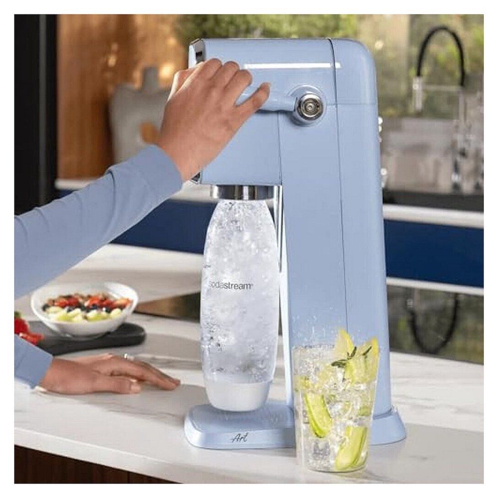 Person benutzt SodaStream Art Misty Blue, um Wasser in ein Glas zu sprudeln.