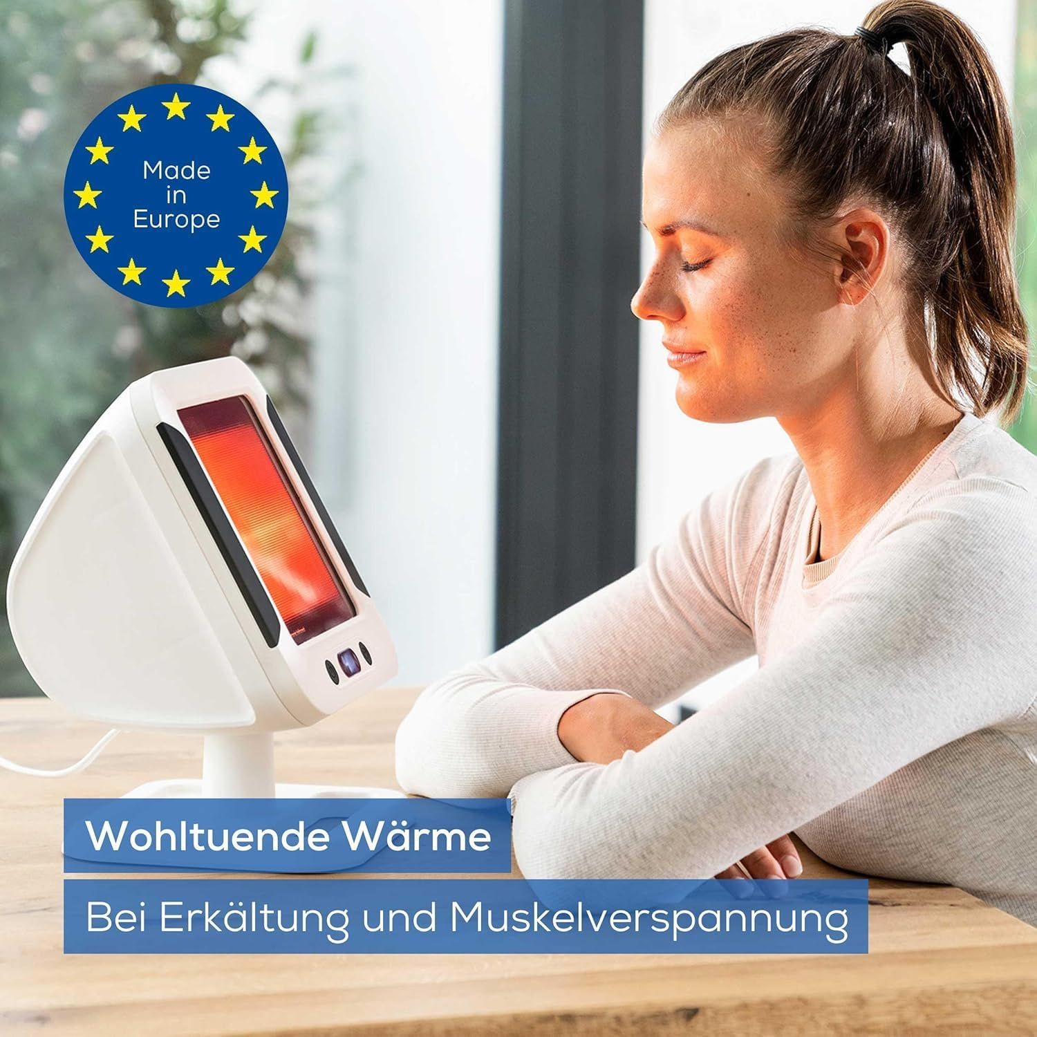 Weißer Infrarot-Wärmestrahler. Frau sitzt vor dem Gerät. Aufschrift: Wohltuende Wärme bei Erkältung und Muskelverspannung. Made in Europe.