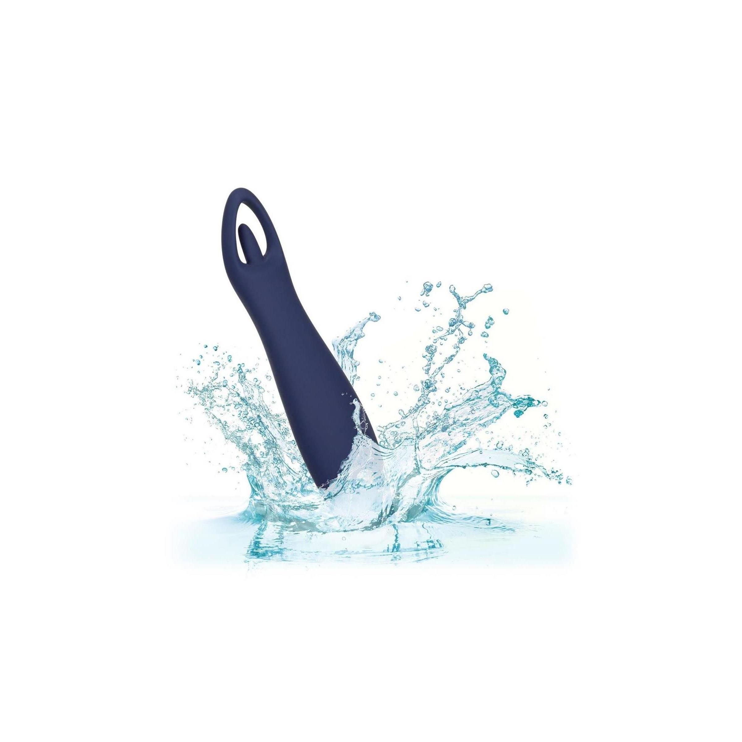 Dunkelblauer Vibrator im Wasser. Wasserspritzer um das Produkt.