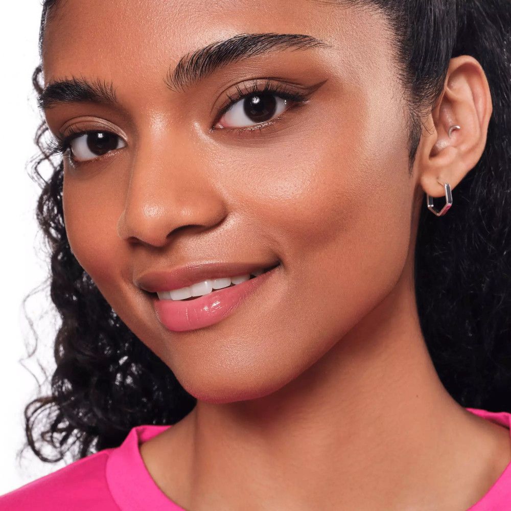 Frau mit pinkem Oberteil, Eyeliner am Auge.