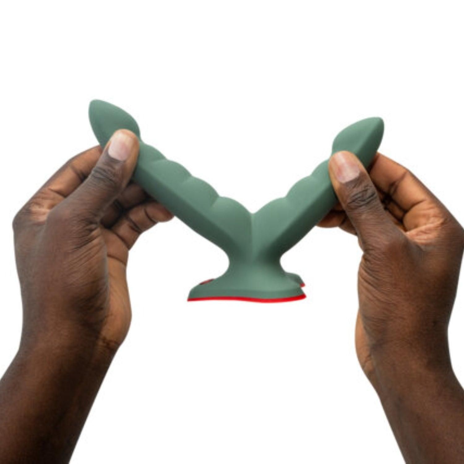 Grüner Doppeldildo, gehalten von zwei Händen. Der Sockel ist rot. Das Produkt hat eine wellenförmige Oberfläche.