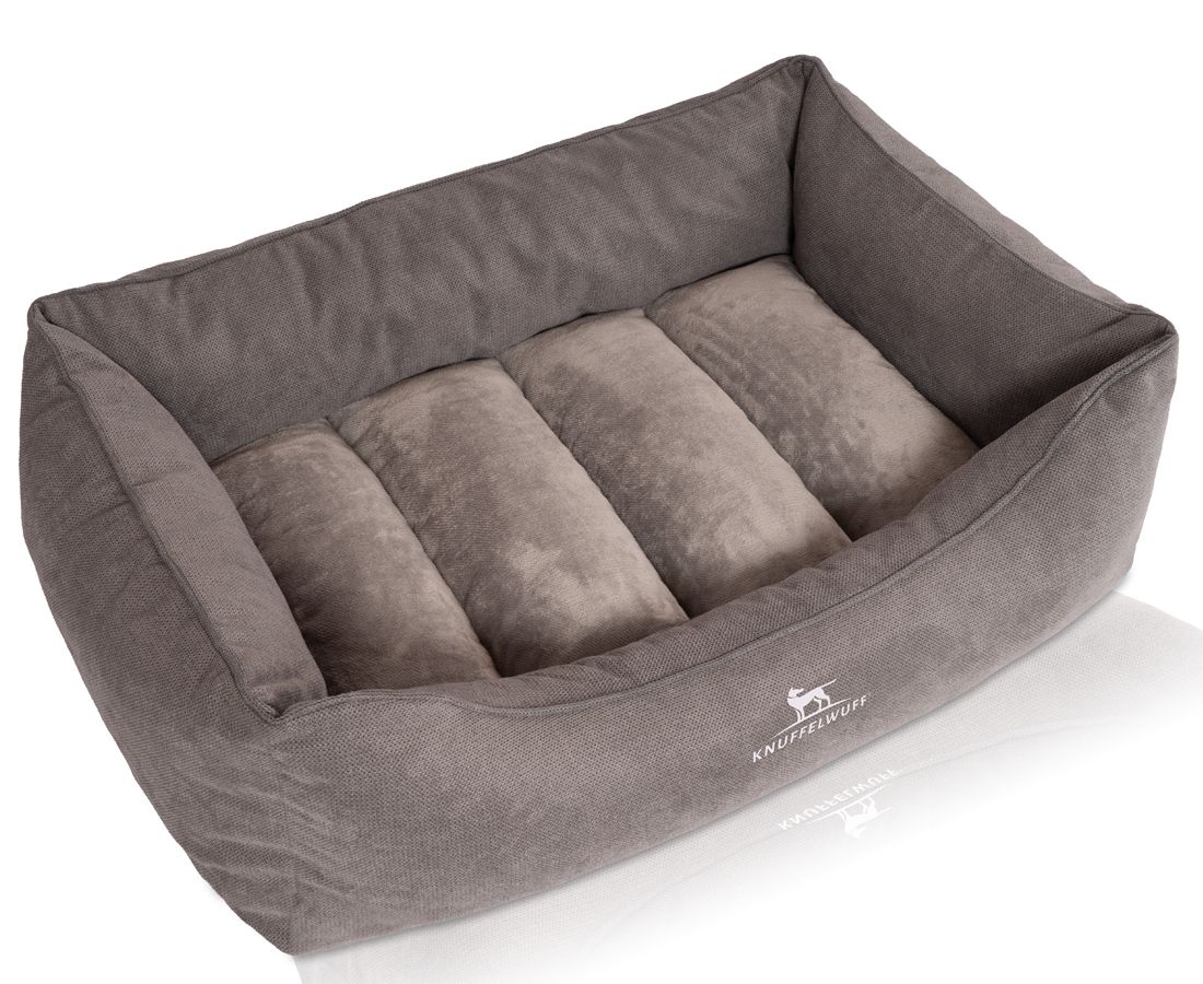 Graues orthopädisches Hundebett. Rechteckige Form mit erhöhten Seiten und vier Kissen. Logo "Knuffelwuff" unten.