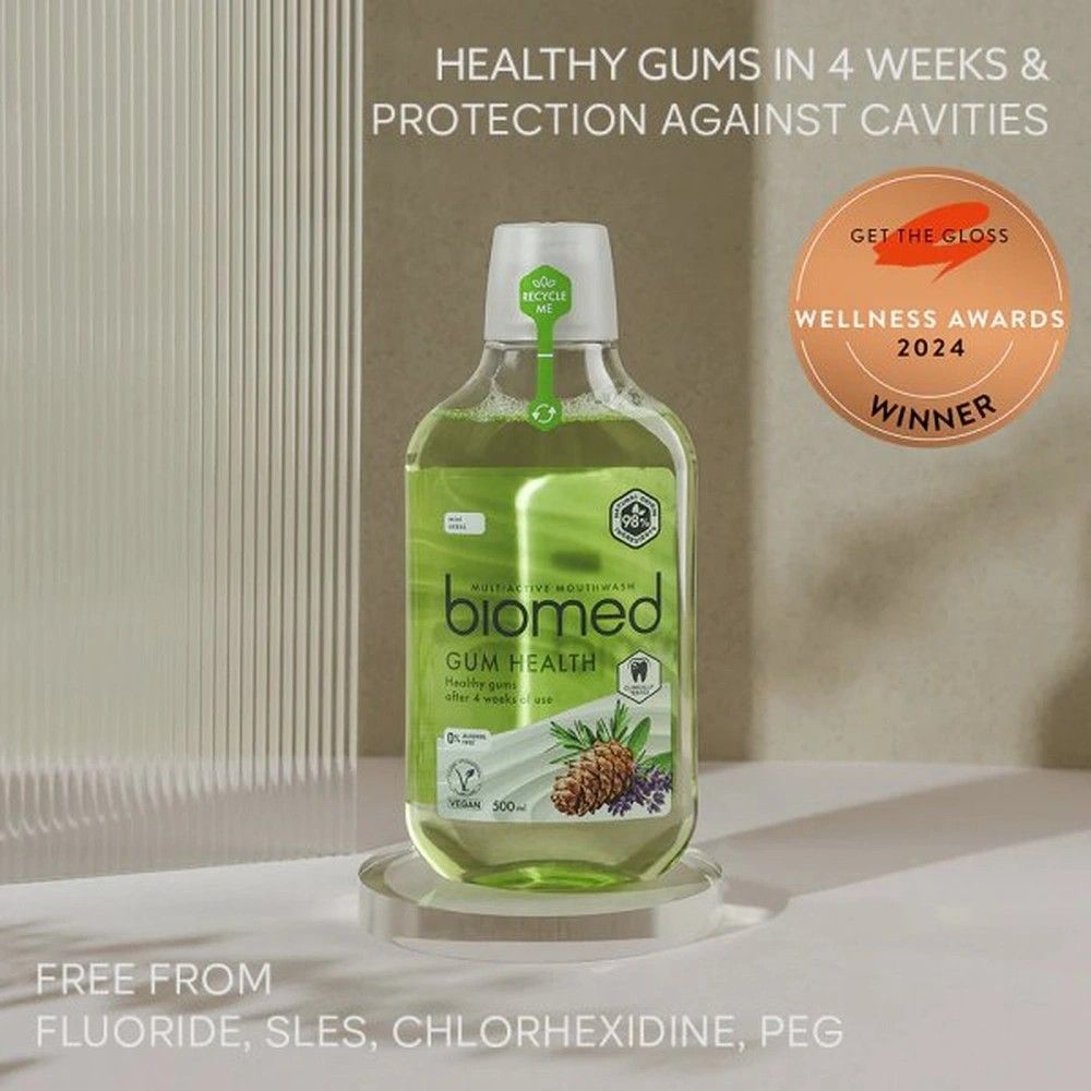 Grüne Mundspülung-Flasche auf Podest. Aufschrift: biomed Gum Health. Auszeichnung: Wellness Awards 2024 Winner. Text: Healthy gums in 4 weeks.
