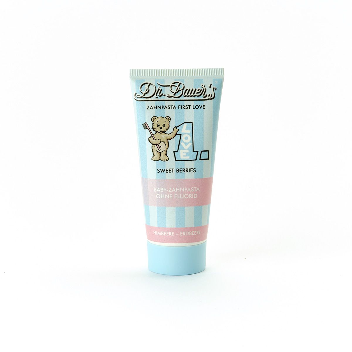Hellblaue Zahnpasta-Tube mit rosa Streifen. Aufschrift: Dr. Bauer's Zahnpasta First Love Sweet Berries ohne Fluorid. Abbildung eines Bären.