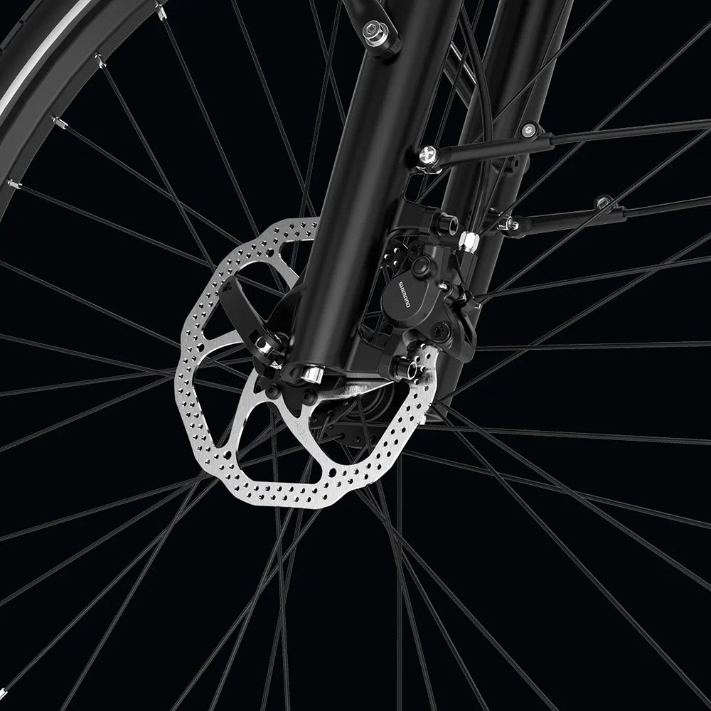 Nahaufnahme der Vorderradbremse eines schwarzen E-Bikes. Scheibenbremse mit Bremssattel und Speichen.