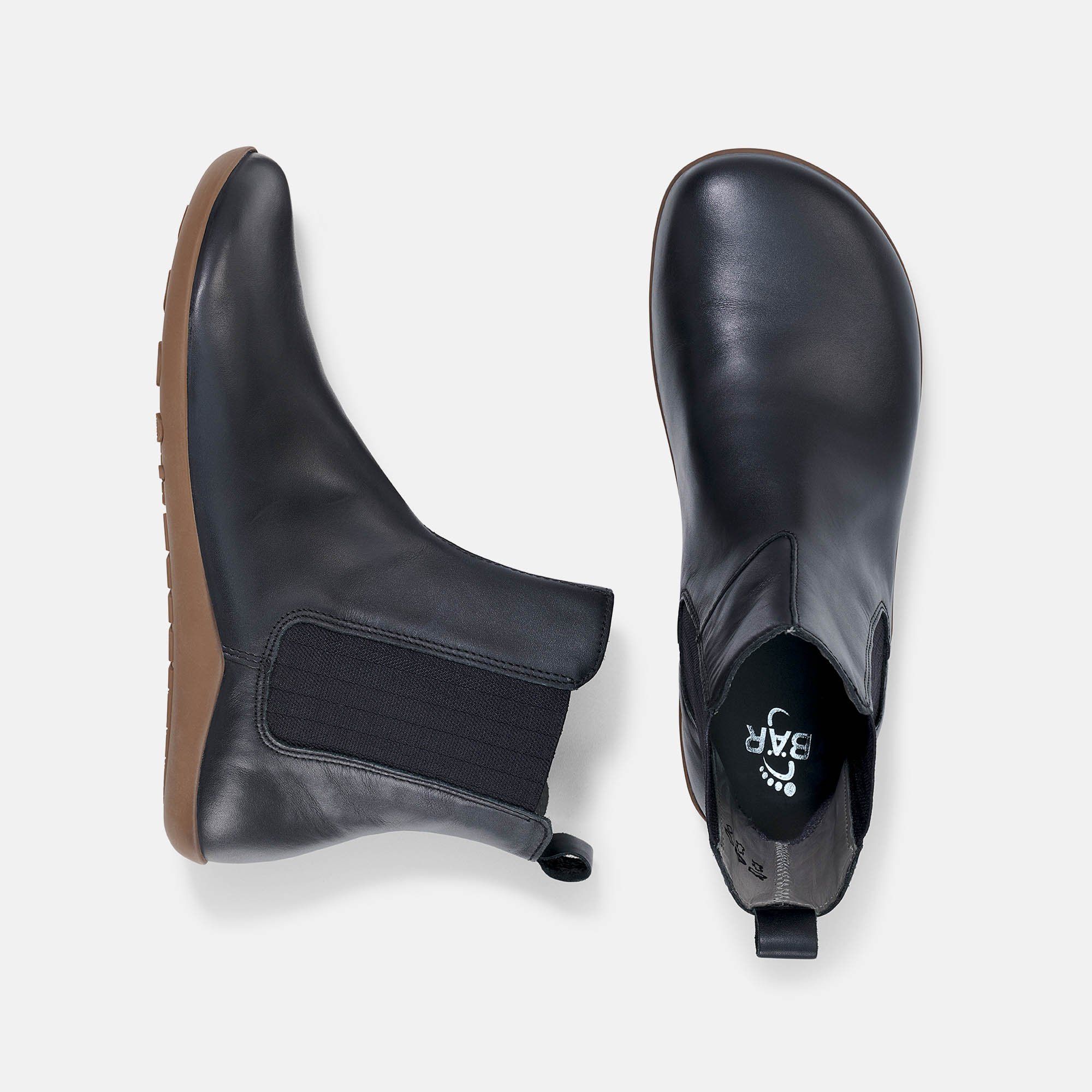 Schwarze Stiefeletten mit brauner Sohle. Elastischer Einsatz an der Seite. Draufsicht auf zwei Schuhe.