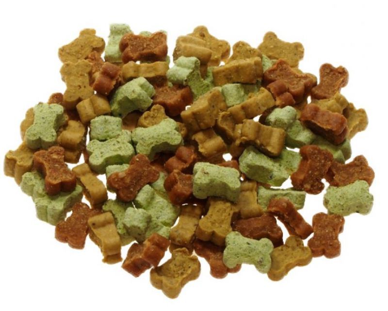 Haufen von Mini-Knochen-Hundesnacks in verschiedenen Farben: braun, grün und beige. Vegetarisch.