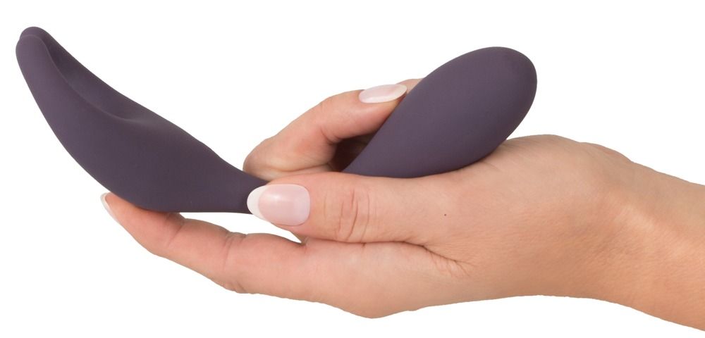 Hand hält lila Vibrator. Geschwungene Form. Glatte Oberfläche. Tropfenförmiger Griff.