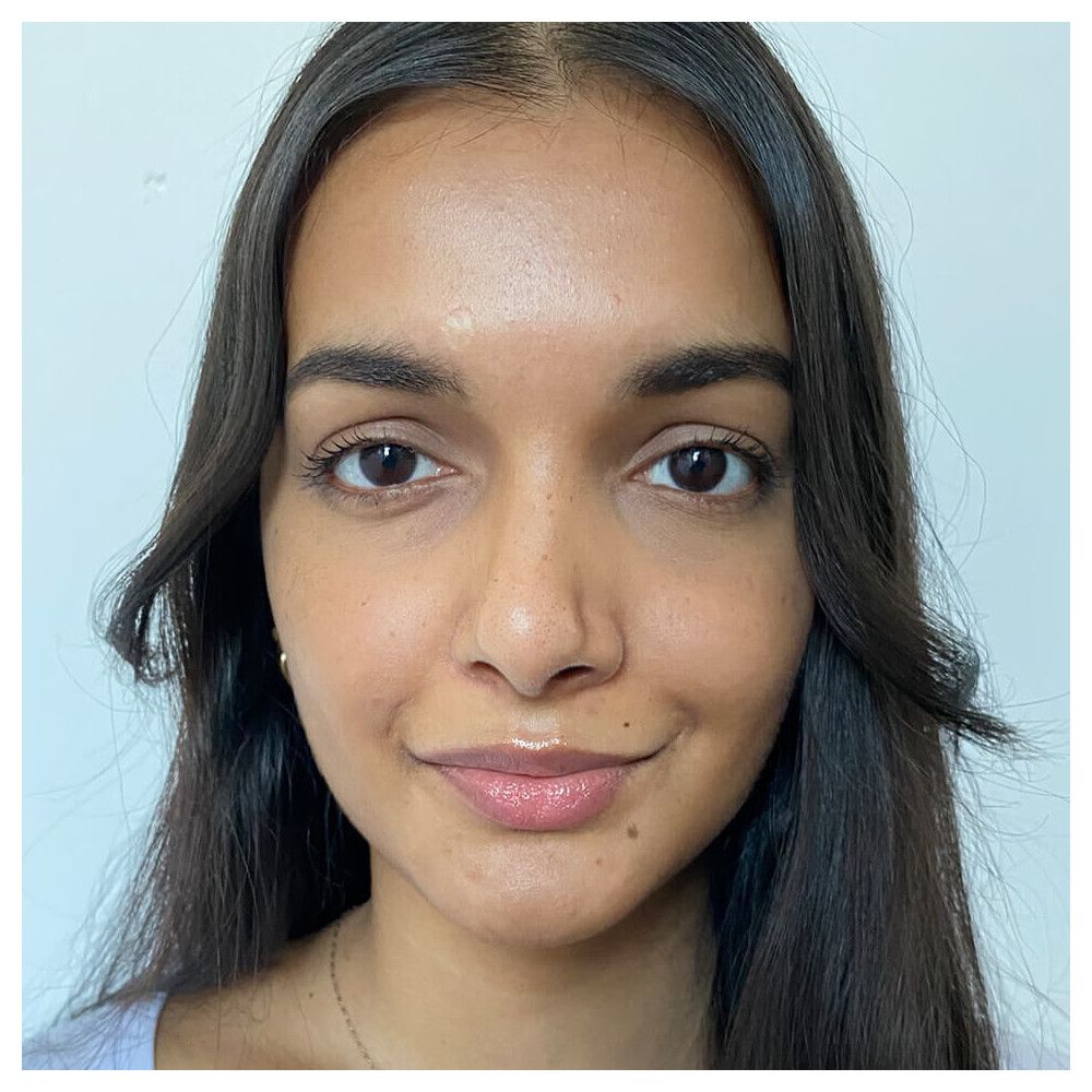 Porträt einer Frau mit braunen Augen und dunklen Haaren. Sie lächelt leicht.