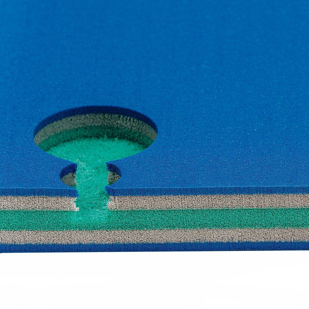 Nahaufnahme einer Judomatte. Blaue Oberfläche, grüne und graue Schichten. Verbindungsstück sichtbar.