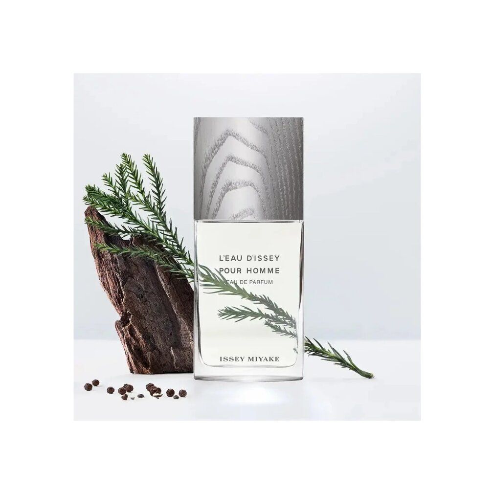 Flakon mit Holzdeckel, neben Zweig und Rinde. Aufschrift: L'EAU D'ISSEY POUR HOMME, Eau de Parfum, ISSEY MIYAKE.