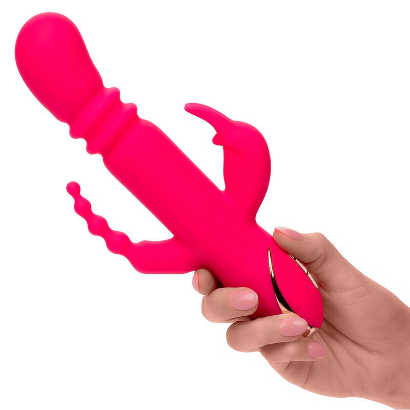 Pinkfarbener Vibrator mit Kaninchenohren und wellenförmigem Element. Goldfarbene Akzente. In Hand gehalten.